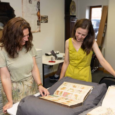 Image shows Liz Hebbron researching archive pattern designs with Collections support Louise Price